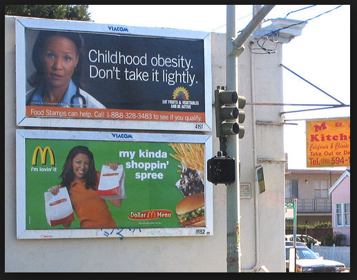 billboards met boven tegen overgewicht bij kinderen en onder een billboard voor MacDonalds